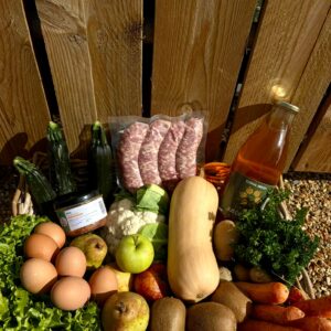 Grand panier de saison : légumes, saucisses maison, œufs et jus de pomme de la ferme
