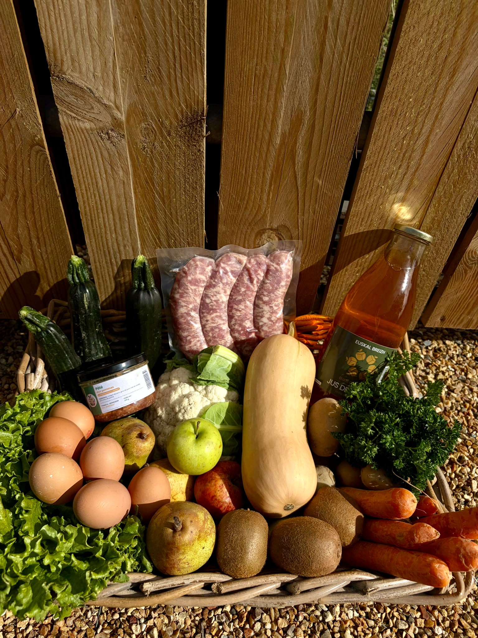 Grand panier de saison : légumes, saucisses maison, œufs et jus de pomme de la ferme